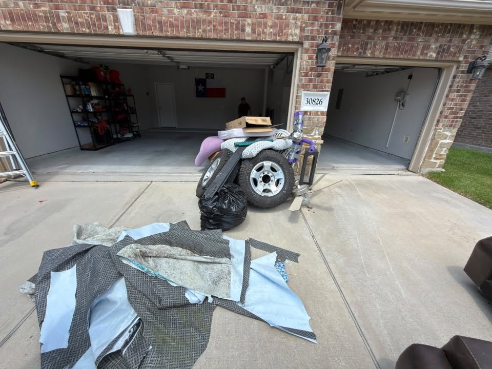 Garage clean-out in progress with items staged on the driveway